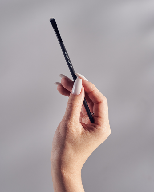 A model holding a lash cleansing brush.