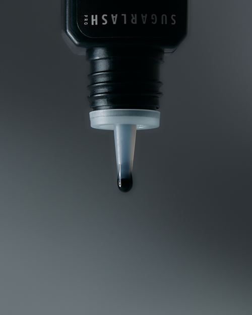 A drop of Bond Noir Adhesive dripping out of the dropper nozzle.