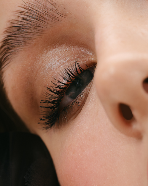 A close up of a model's eyelash extensions who has Glaze applied.