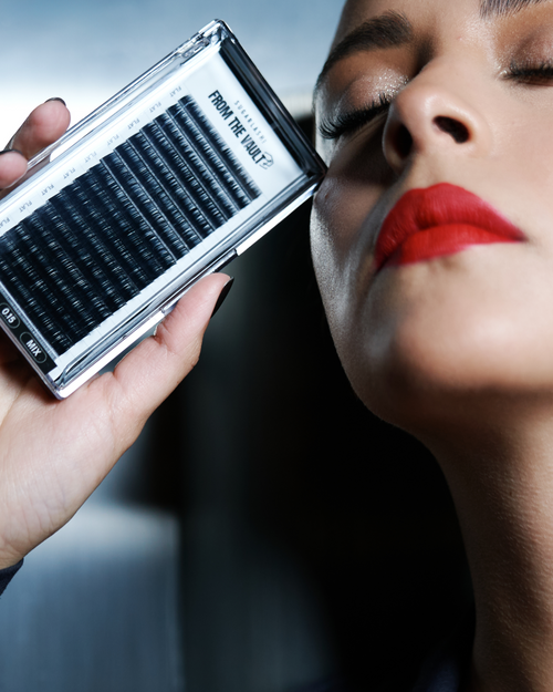 A model holding a tray of From The Vault Flat Lashes for eyelash extensions.