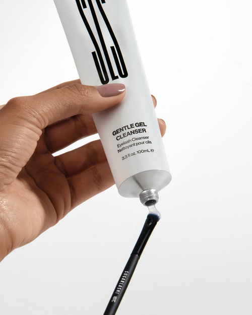 A model putting Gentle Gel Cleanser on to a small brush for eyelash extensions