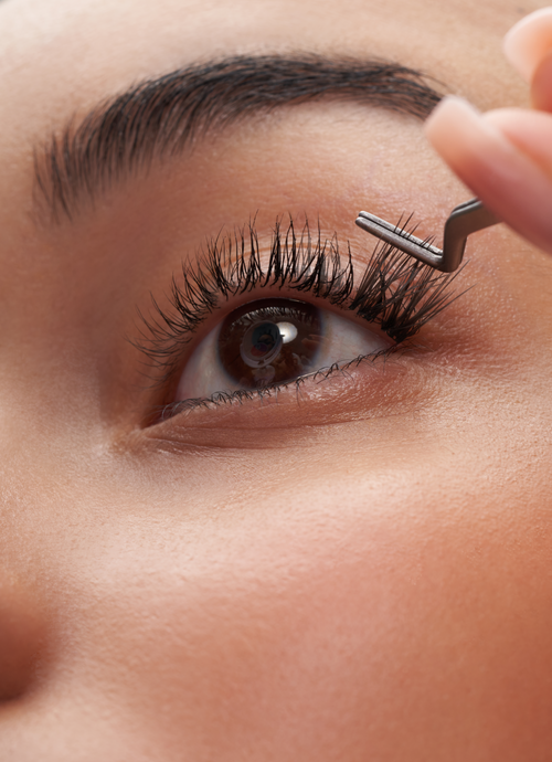 a cluster of false eyelash extensions being applied to a model's eye.