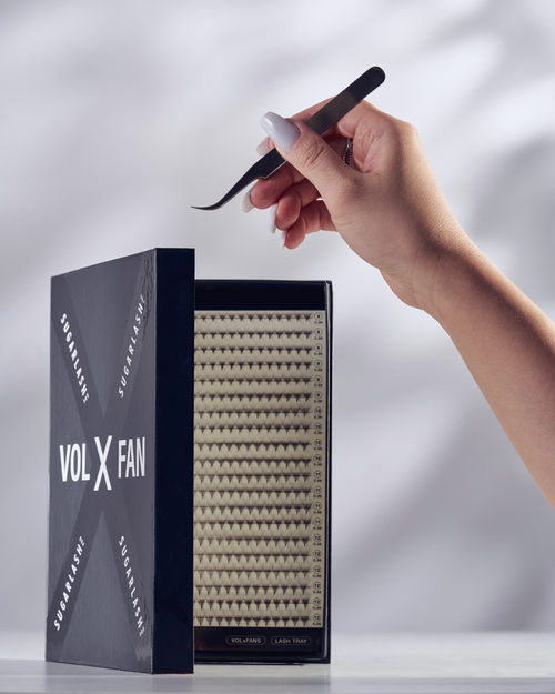 A model holding tweezers over a partially open tray of VOL-X Pre-made Fans.