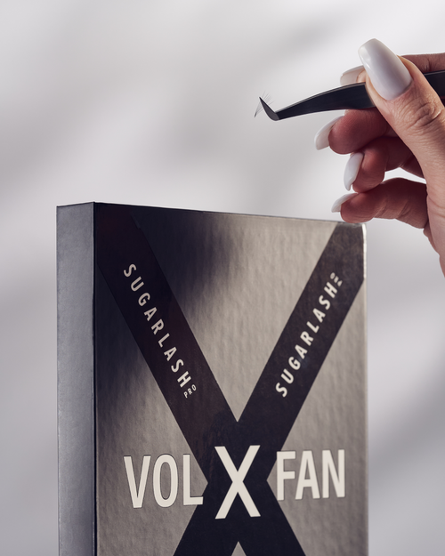 Model holding tweezers above a closed tray of VOL-X pre-made fans.