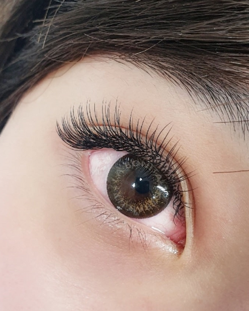 A close up of a model's eye with Flat eylash extensions applied.