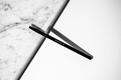 The Professional Lash Lift Brush against a white and a marble background.