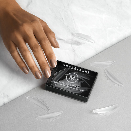 A model reaching for a box of M Professional Lash Lift Shields.